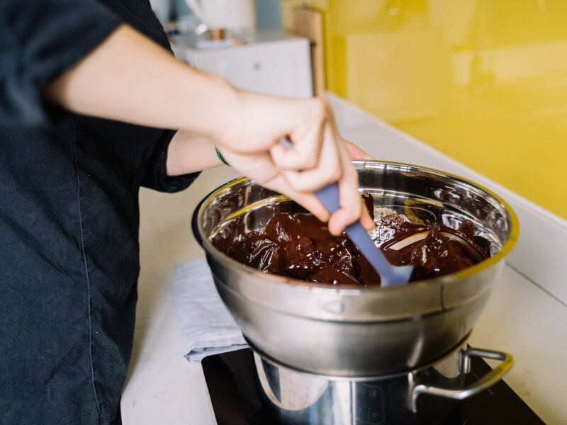 A closeup of melted chocolate being stirred in a bowl.